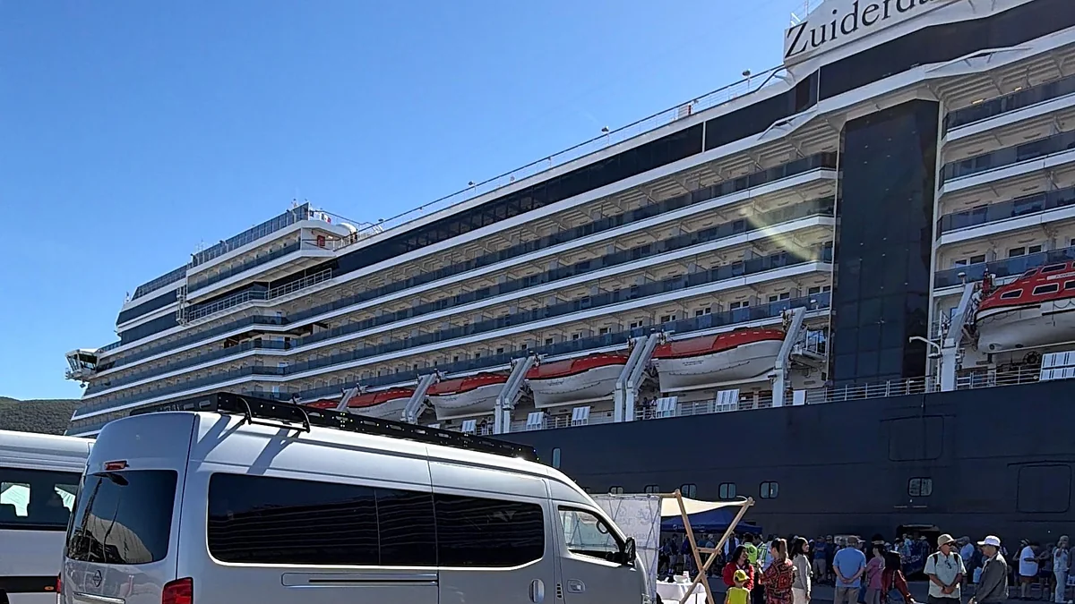 Unidad de la agencia esperando en el muelle junto a un crucero